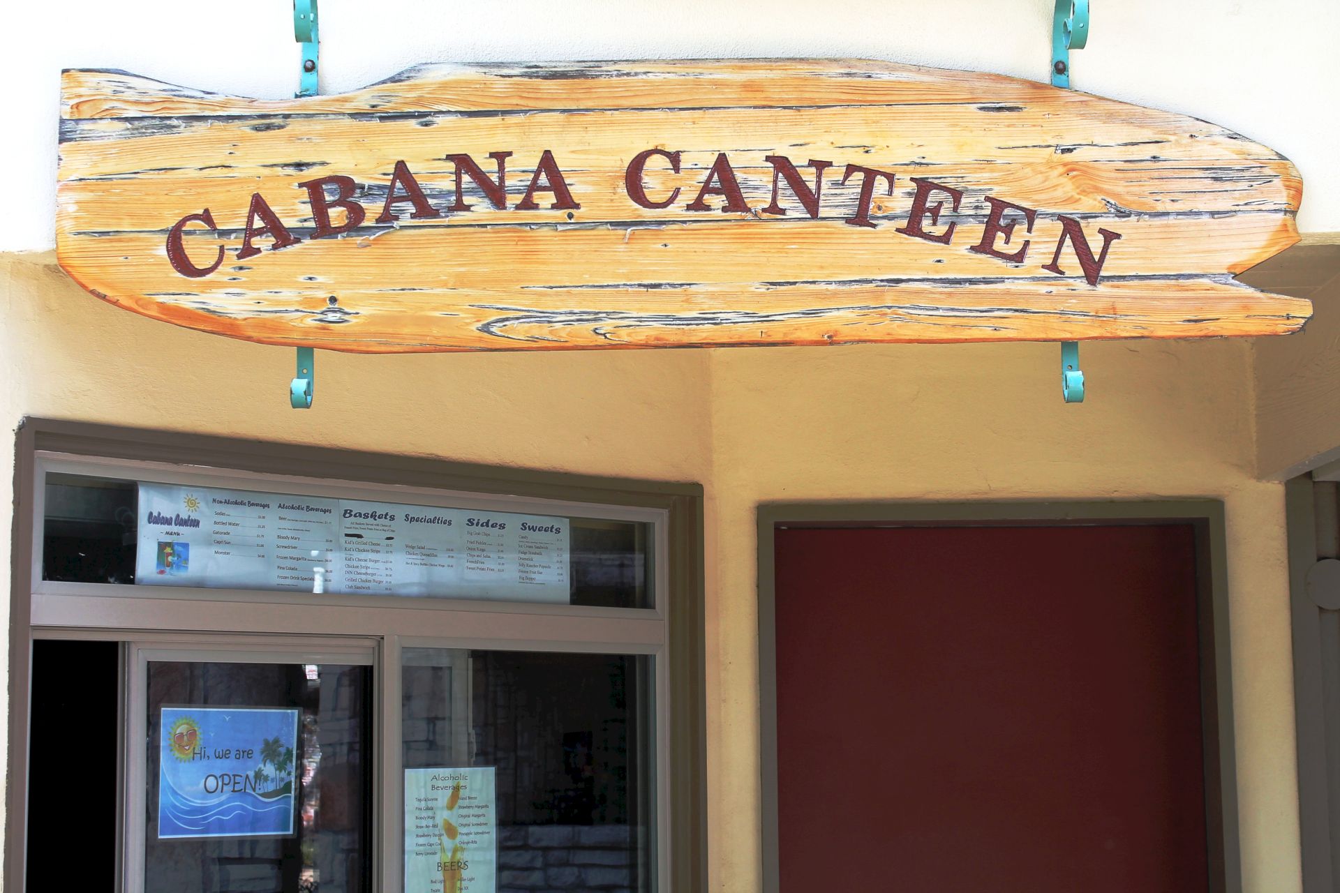 A wooden sign above a restaurant entrance reads &ldquo;CABA&Ntilde;A CANTEEN,&rdquo; with menu boards in the window below.