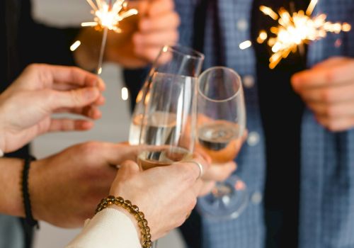 A celebration with people toasting sparklers and glasses of champagne. Always ending the sentence.